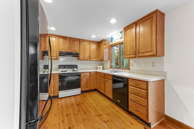 10 Bradford Ln, Eastham, MA 02642 - kitchen featuring black appliances, under cabinet range hood, light wood finished floors, tasteful backsplash, and recessed lighting