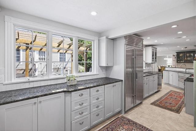 72 River Rd, Marstons Mills, MA 02648 - kitchen with appliances with stainless steel finishes, light tile patterned flooring, recessed lighting, and dark stone countertops