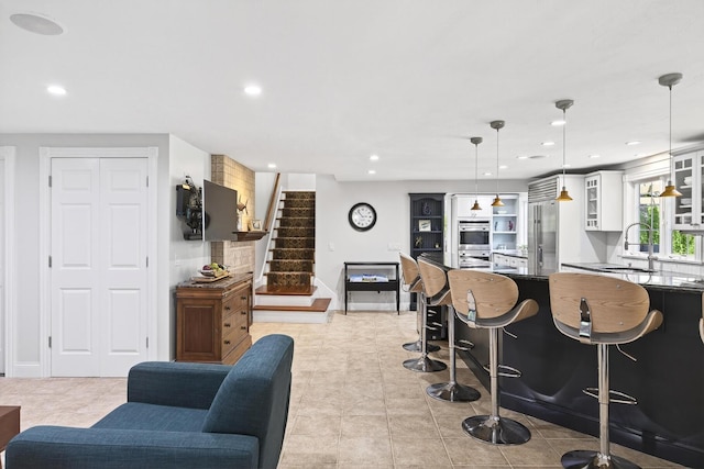 72 River Rd, Marstons Mills, MA 02648 - kitchen featuring appliances with stainless steel finishes, white cabinetry, recessed lighting, glass insert cabinets, and a kitchen bar