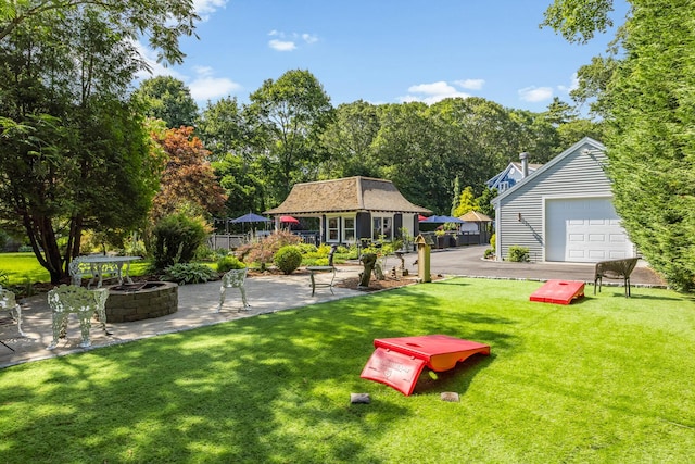 72 River Rd, Marstons Mills, MA 02648 - view of yard featuring an outdoor structure, a fire pit, a patio area, a detached garage, and view of scattered trees