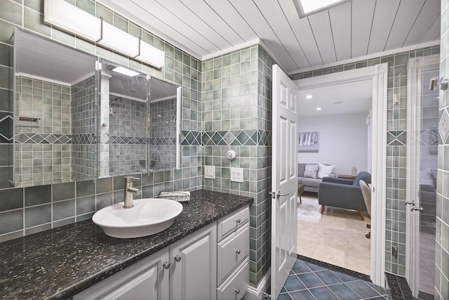 72 River Rd, Marstons Mills, MA 02648 - ensuite bathroom featuring tile walls, vanity, tile patterned flooring, and tasteful backsplash