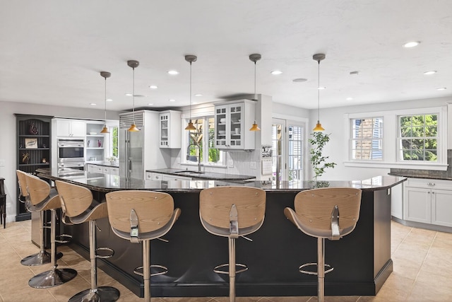 72 River Rd, Marstons Mills, MA 02648 - kitchen featuring light tile patterned floors, appliances with stainless steel finishes, glass insert cabinets, a breakfast bar, and recessed lighting