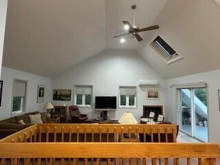 living room with ceiling fan and lofted ceiling