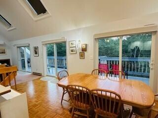 dining space with vaulted ceiling and parquet flooring