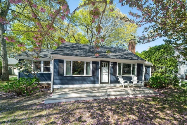 view of front of home with a chimney and a porch
