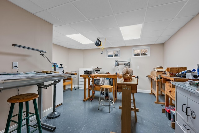 office with a drop ceiling and a workshop area