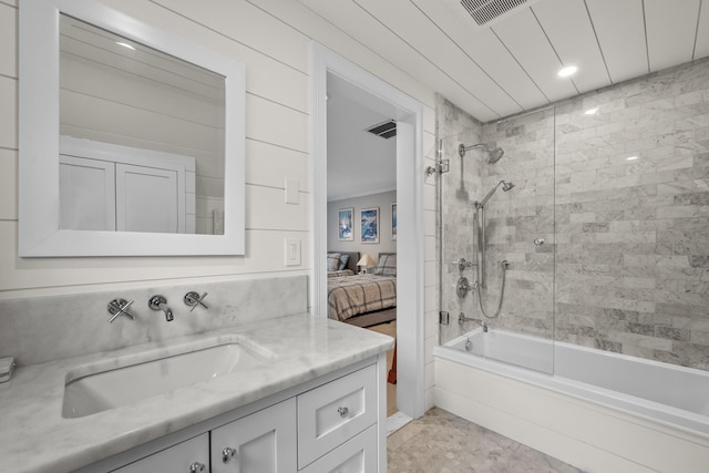 bathroom featuring vanity and tiled shower / bath