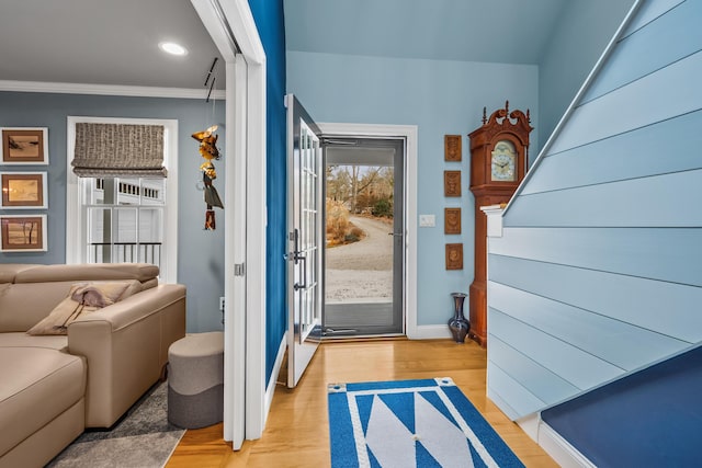 doorway with ornamental molding and light wood-type flooring