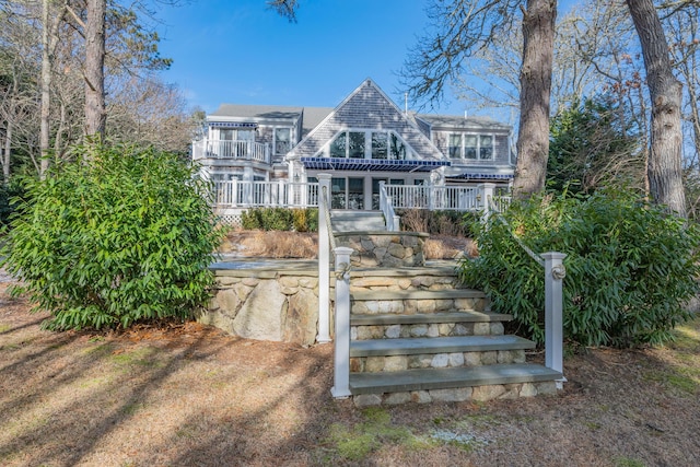 back of property featuring a balcony and covered porch