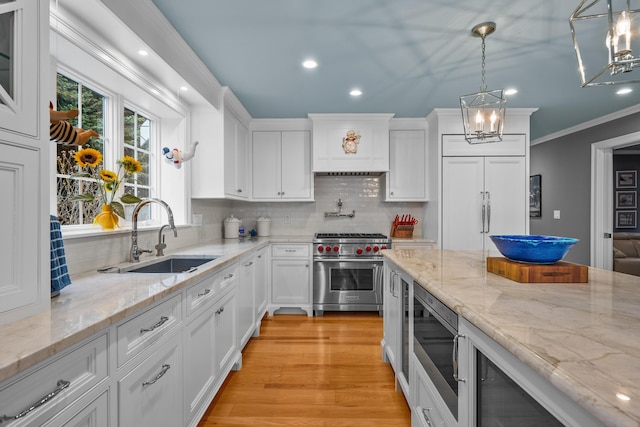 kitchen with white cabinetry, built in appliances, and decorative light fixtures