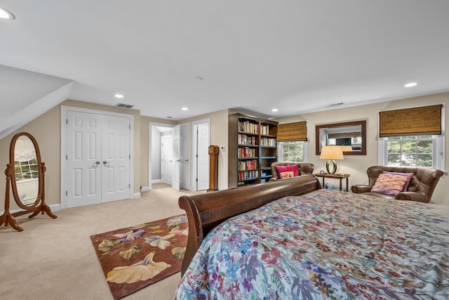 bedroom with light carpet and multiple closets