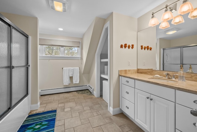 bathroom featuring vanity, combined bath / shower with glass door, and a baseboard heating unit