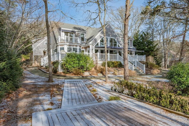 back of property featuring a balcony and covered porch