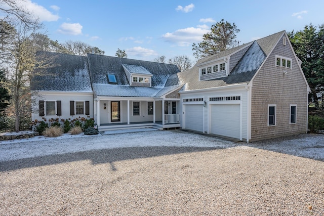 cape cod-style house with a garage and a porch