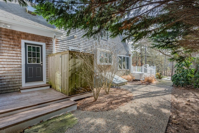 property entrance with a wooden deck and central air condition unit