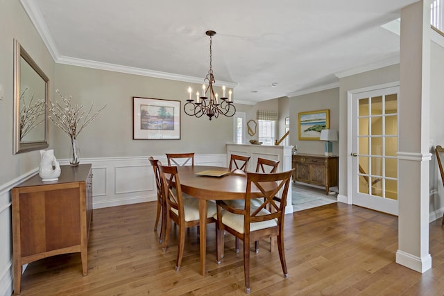 9 Sea Knoll Ct, Bourne, MA 02532 - dining area featuring ornamental molding, wood finished floors, a chandelier, and a wainscoted wall