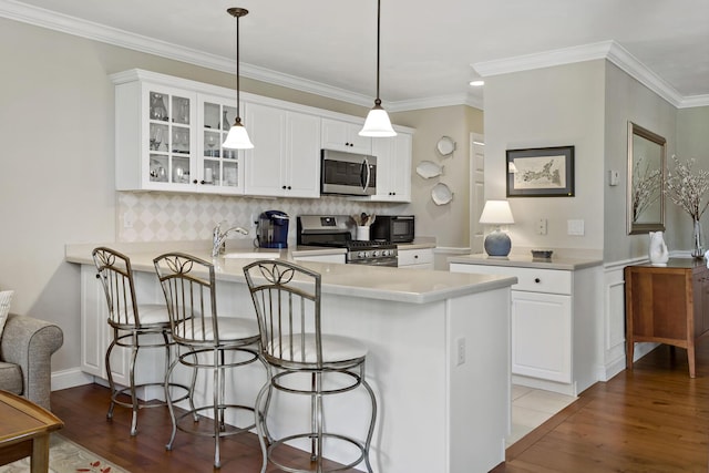 9 Sea Knoll Ct, Bourne, MA 02532 - kitchen with appliances with stainless steel finishes, glass insert cabinets, tasteful backsplash, a kitchen breakfast bar, and wood finished floors