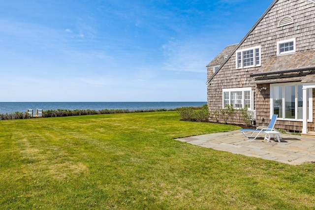 view of yard featuring a water view and a patio area