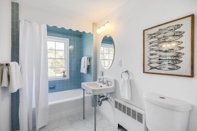 full bathroom with toilet, shower / tub combo with curtain, tile patterned floors, baseboards, and radiator heating unit