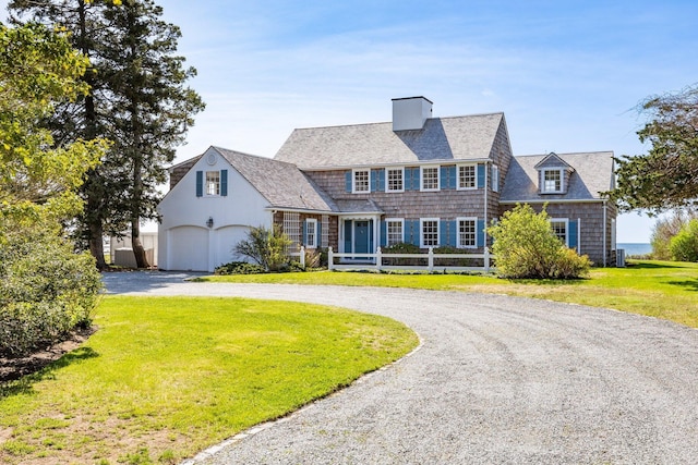 view of front facade featuring a garage, a chimney, fence, curved driveway, and a front lawn