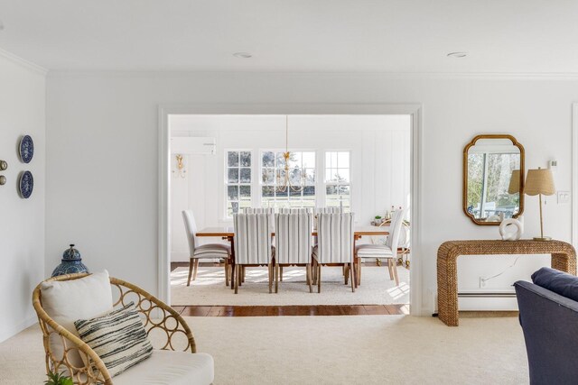 dining space with baseboards, a baseboard heating unit, carpet flooring, and crown molding