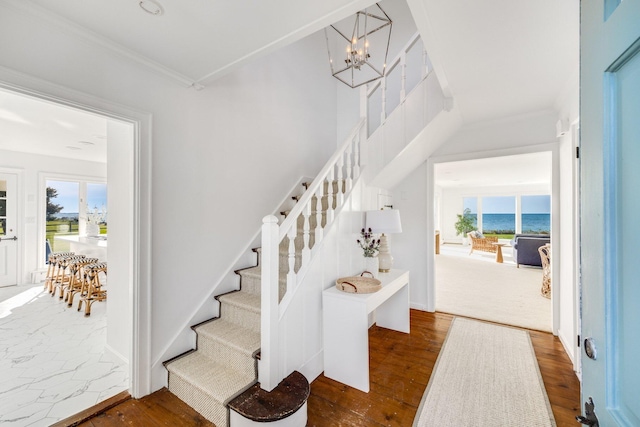 stairs with crown molding, a chandelier, wood-type flooring, and a wealth of natural light