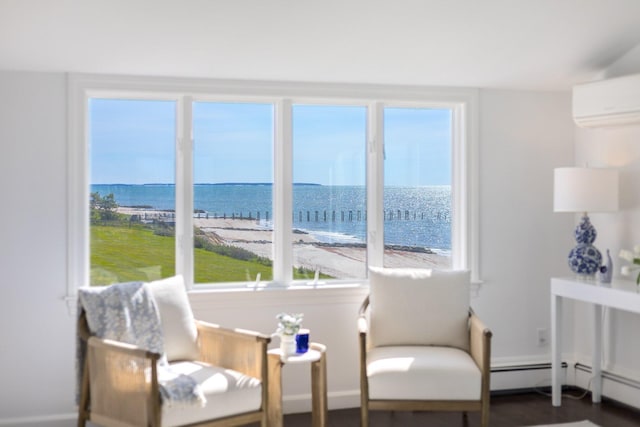 sitting room featuring a water view, baseboards, and a wall mounted AC