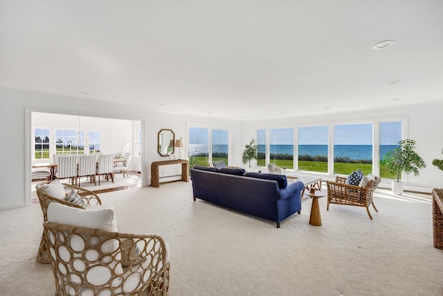 living area featuring a water view, plenty of natural light, and carpet floors