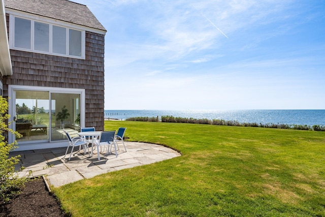 view of yard with a water view and a patio