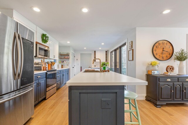 3 Bramblewood Ln, Orleans, MA 02653 - kitchen featuring light wood finished floors, a kitchen breakfast bar, light countertops, a sink, and appliances with stainless steel finishes