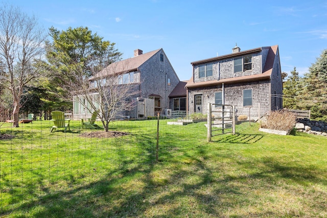 3 Bramblewood Ln, Orleans, MA 02653 - back of house with a lawn, fence, and a chimney