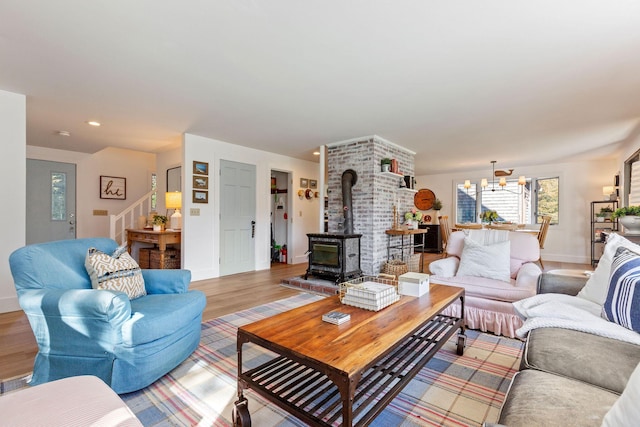 3 Bramblewood Ln, Orleans, MA 02653 - living room with a wood stove, baseboards, light wood-style flooring, stairs, and a notable chandelier