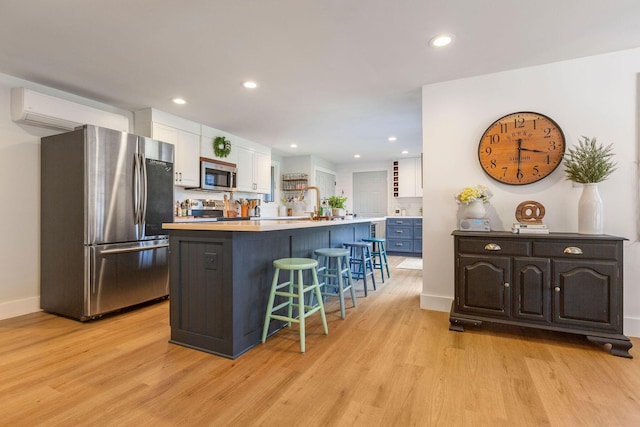3 Bramblewood Ln, Orleans, MA 02653 - kitchen featuring white cabinets, light countertops, a breakfast bar, light wood-style floors, and appliances with stainless steel finishes