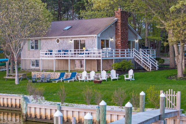 30 Overland Rd, Mashpee, MA 02649 - rear view of house featuring a wooden deck, a lawn, a chimney, and a shingled roof