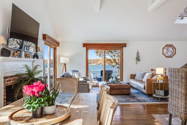 living area featuring a fireplace, wood finished floors, and high vaulted ceiling