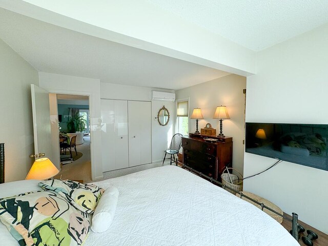 carpeted bedroom with a closet and a wall unit AC