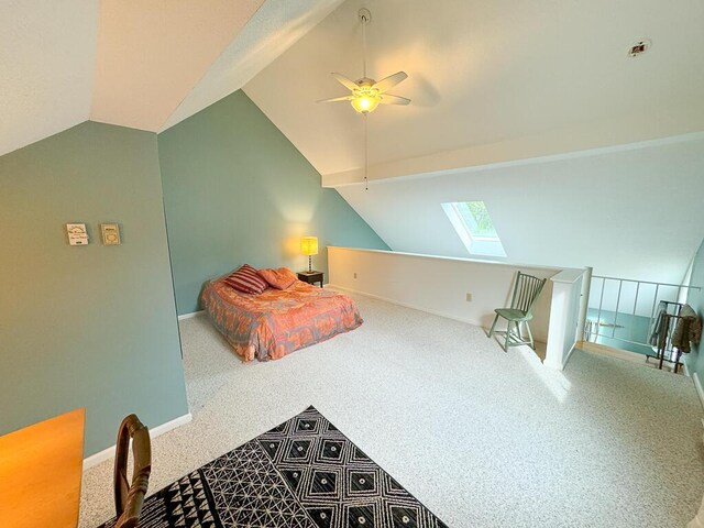 bedroom featuring carpet flooring, vaulted ceiling with skylight, and ceiling fan