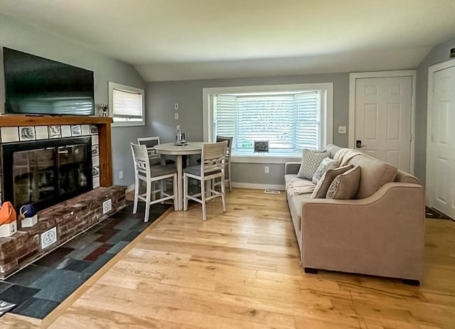 31 Northern Ave, Dennis Port, MA 02639 - living room featuring vaulted ceiling, a brick fireplace, wood finished floors, plenty of natural light, and baseboards