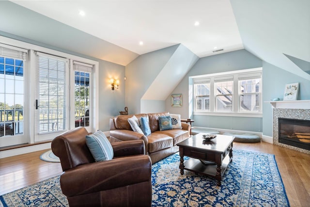 living room with hardwood / wood-style flooring, a fireplace, and lofted ceiling