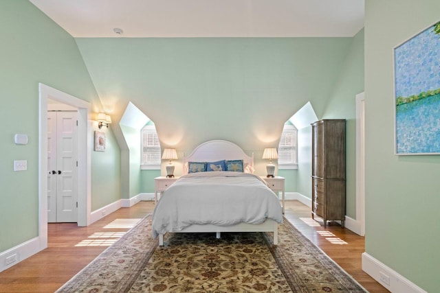 bedroom featuring light hardwood / wood-style floors and lofted ceiling