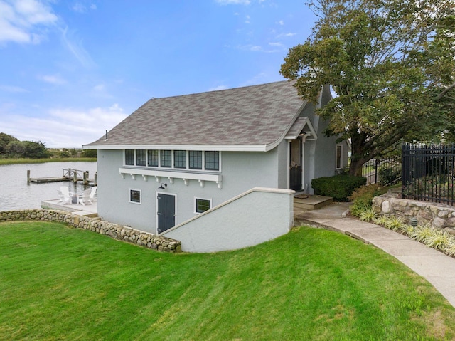 rear view of property featuring a water view and a yard