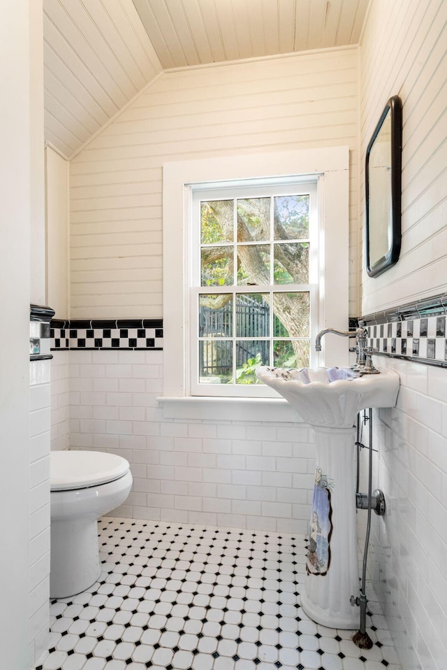 bathroom with toilet, wood ceiling, tile walls, tile patterned floors, and vaulted ceiling