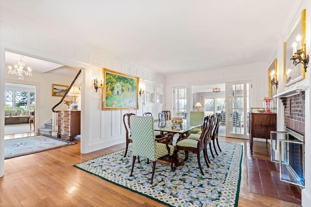 dining area with french doors, hardwood / wood-style floors, ornamental molding, and a notable chandelier