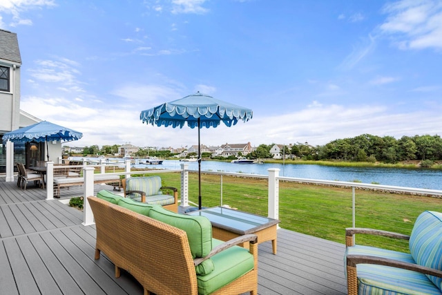 wooden deck with an outdoor living space, a water view, and a yard