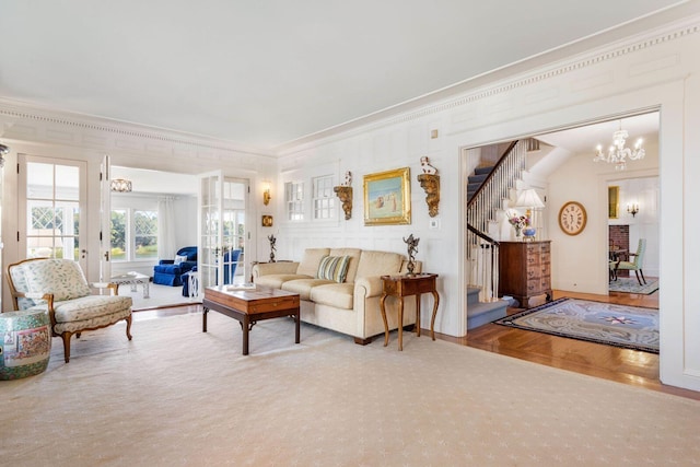 living room with a notable chandelier, ornamental molding, and parquet floors