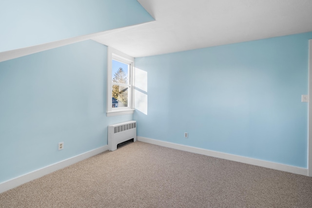 additional living space with radiator heating unit and light carpet