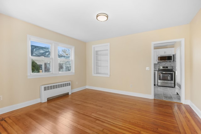 empty room with radiator and light hardwood / wood-style flooring