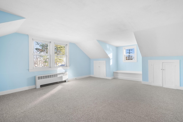 bonus room featuring carpet flooring, radiator, and lofted ceiling