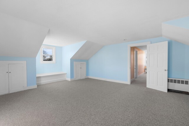 bonus room with light colored carpet, radiator, and lofted ceiling