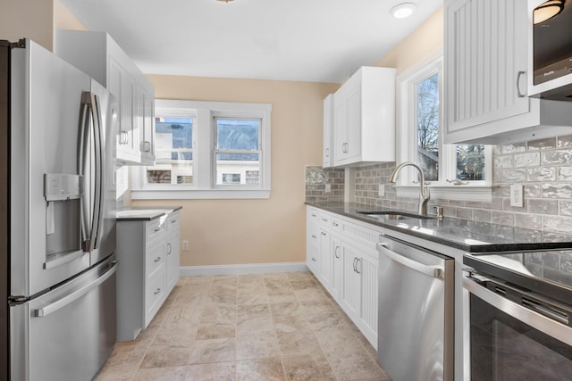 kitchen featuring sink, white cabinetry, backsplash, and stainless steel appliances